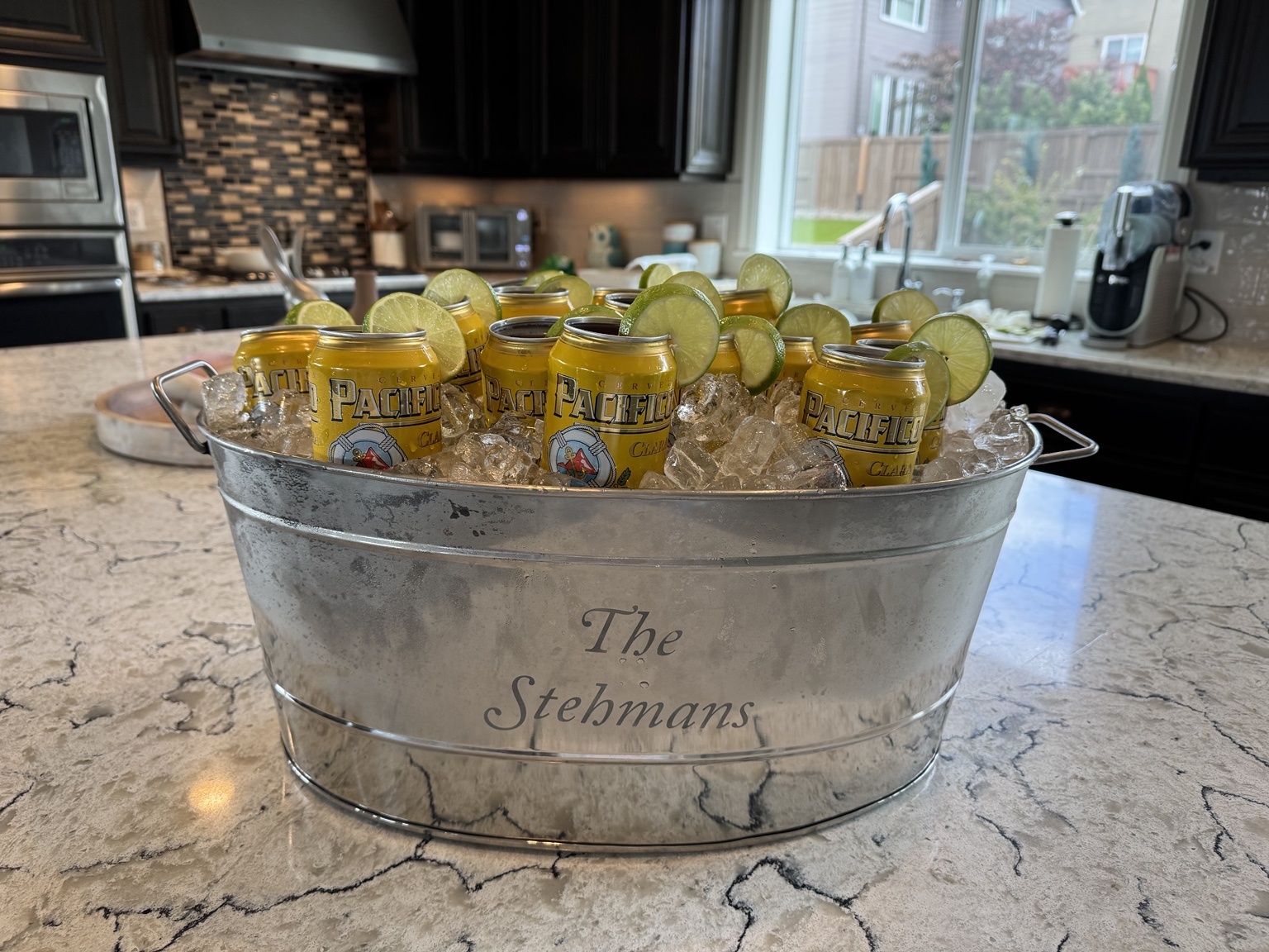 A galvanized tub filled with cold drinks and lime