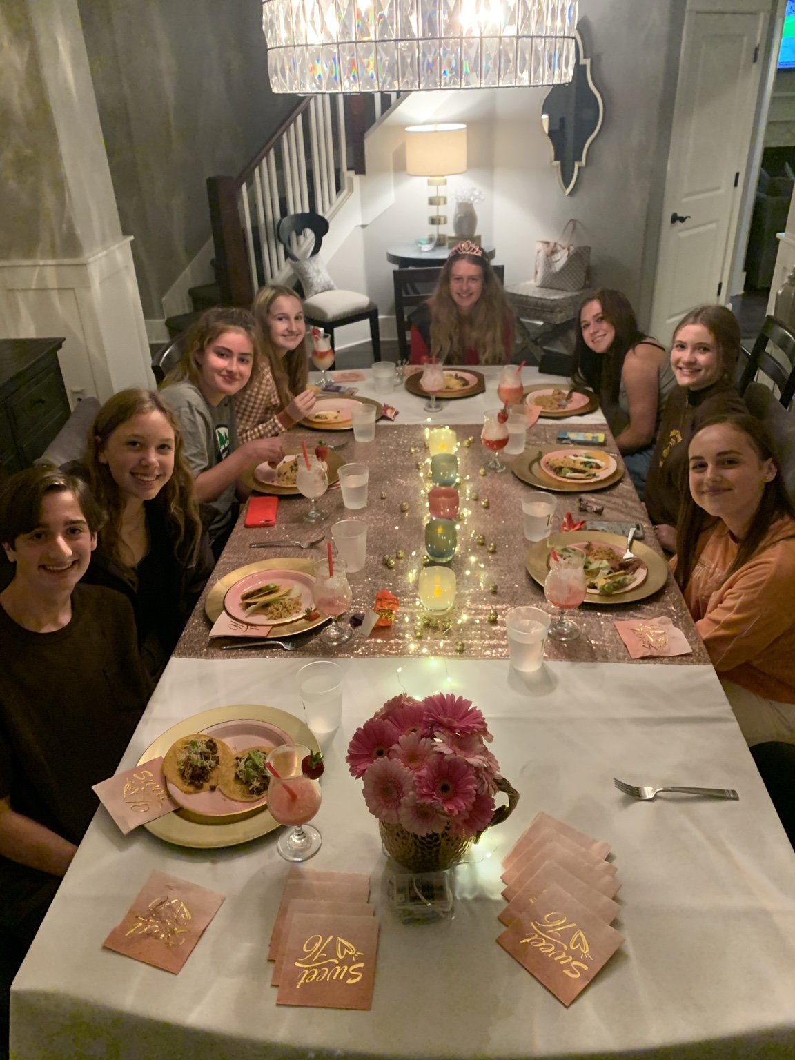 A group of friends gathered around a pink taco dinner table